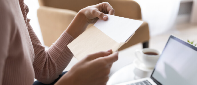 Close up side view young woman holding craft paper envelope correspondence