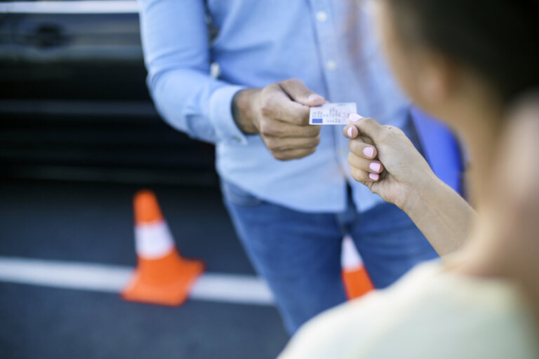 man handing his license to woman