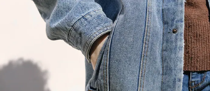 Person is holding hand in denim jacket's pocket
