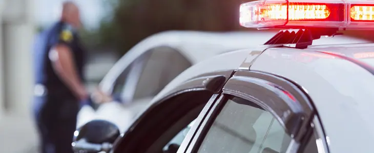 White police car pulls over a white sedan in a cloudy day