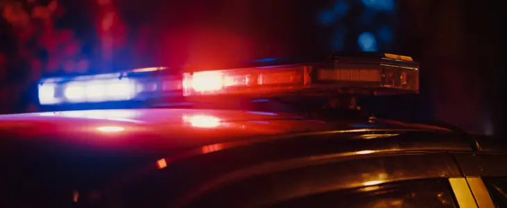 Assault or self defense? Cop car with flashing lights
