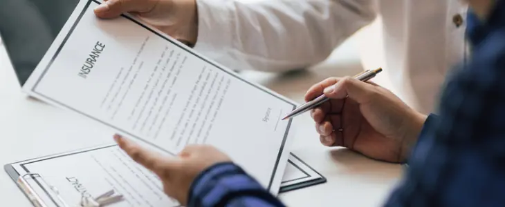 Insurance agent showing a client insurance papers